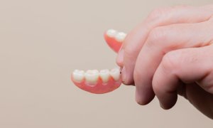 Hand holding a denture